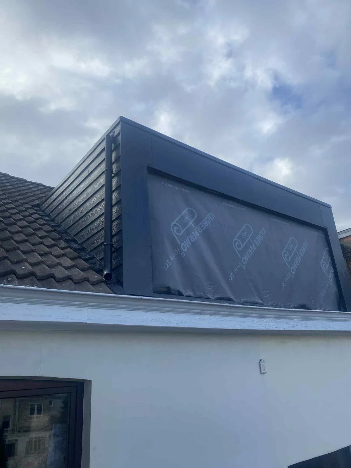 Lucarne en cours de rénovation : écran de sous-toiture posé sur le pignon avant l'habillage