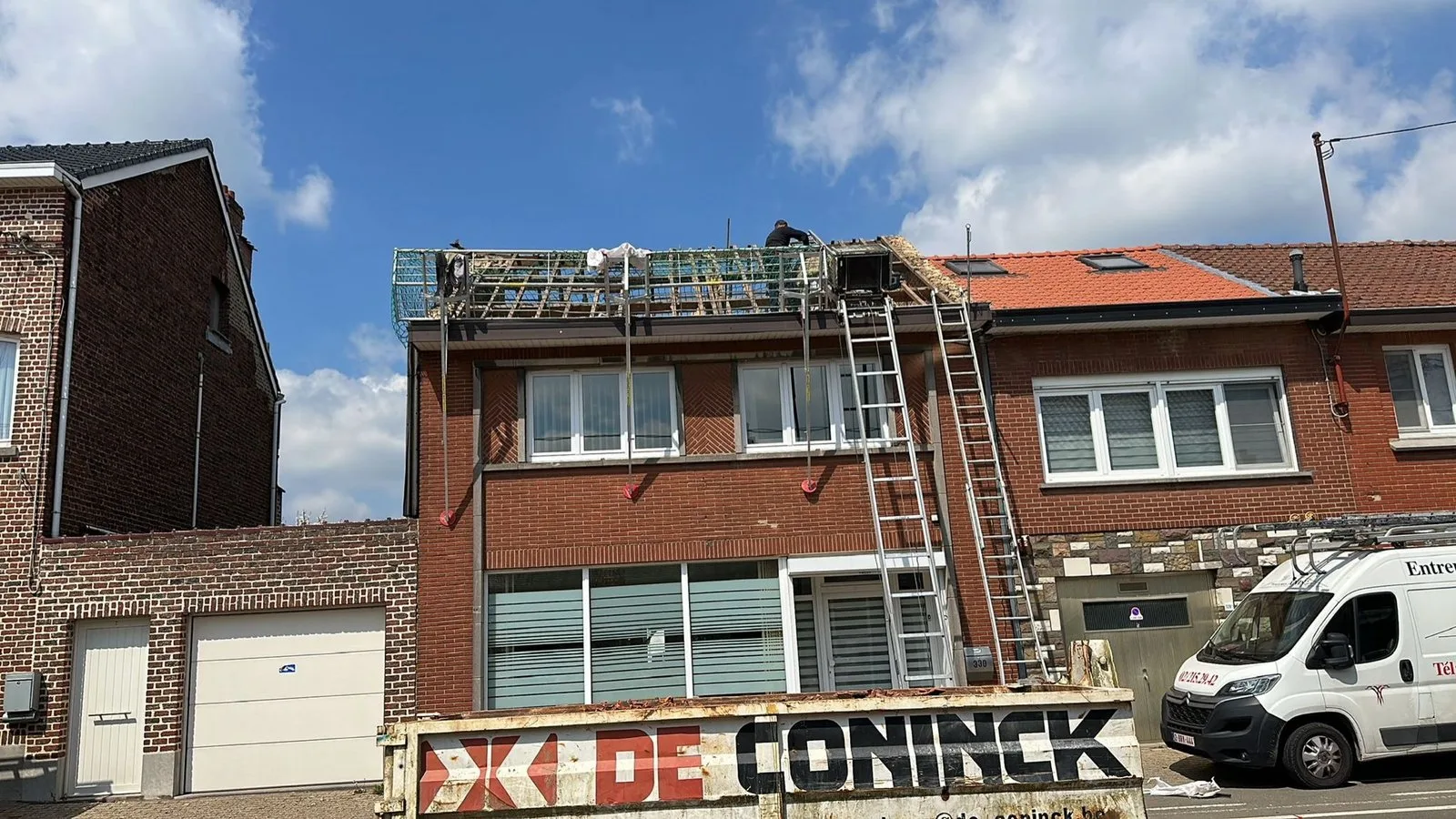 Immeuble en briques rouges en cours de réfection de toiture, échafaudage en façade